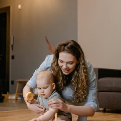 A Woman Playing with Her Baby while Sitting on the Floor