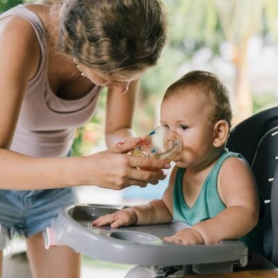 Photo Of Woman Assisting Baby