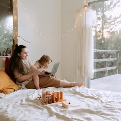 Woman with small girl cheerfully using laptop